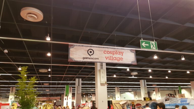Hinweisschild zum Cosplay Village in einer Gamescom-Messehalle 2019.